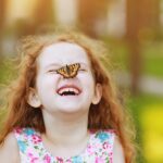 Happy-girl-with-butterfly-on-nose